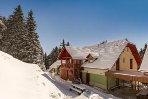 ein Haus im Schnee mit Bäumen im Hintergrund in der Unterkunft Apartma Valsar Rogla in Zreče