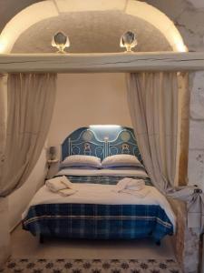 Schlafzimmer mit einem Bett mit blauem Baldachin in der Unterkunft Antiqua Nova in Ceglie Messapica