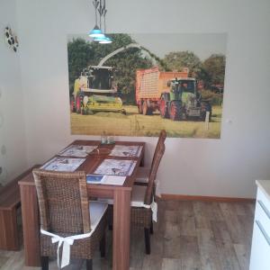 uma sala de jantar com uma mesa e uma pintura de tractores em Haus-in-Gemuenden-an-der-Wohra em Gemünden an der Wohra
