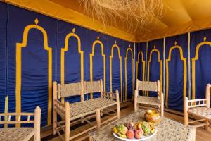 a room with two chairs and a table with a plate of fruit at Riad AZARO in Marrakesh