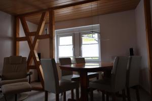 ein Esszimmer mit einem Tisch, Stühlen und einem Fenster in der Unterkunft Ferienwohnung Engelsbach in Engelsbach