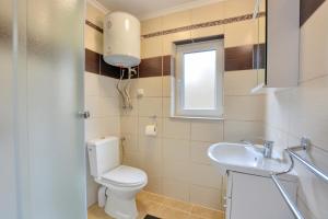 a bathroom with a toilet and a sink at Słoneczny Brzeg Polańczyk Domki 8-osobowe in Polańczyk