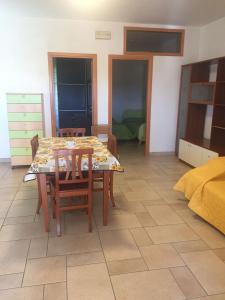 a dining room with a table and chairs and a bedroom at Villa Rinaldi apartment in Vieste