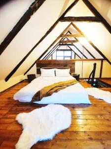 a bedroom with a bed with two white furry pillows at Casuta Bucuriei in Hunedoara
