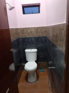 a bathroom with a white toilet and a window at Homestay Armand Pengkalan Balak Melaka in Masjid Tanah