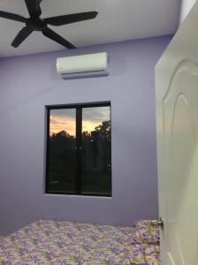 a bedroom with a ceiling fan and a window at Homestay Armand Pengkalan Balak Melaka in Masjid Tanah