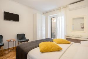 una camera con un letto con due cuscini gialli di Apartment Banje Beach 3 a Dubrovnik