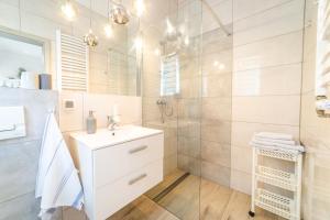 a white bathroom with a sink and a shower at Pokoje u Matiego in Mikołajki +13 photos