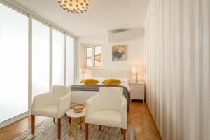 - une chambre avec un lit, deux chaises et une table dans l'établissement Apartment Banje Beach 3, à Dubrovnik