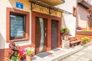 a brick building with a door and potted plants at Pokoje u Matiego in Mikołajki
