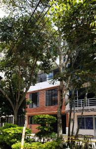 a brick building with trees in front of it at Mapalay House in Ibagué