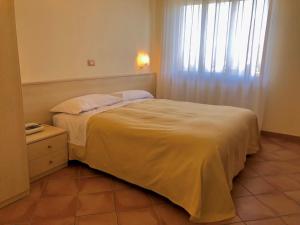sypialnia z dużym łóżkiem i oknem w obiekcie Hotel Di Rocco w mieście Loreto Aprutino +37 zdjęć