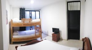 a room with two bunk beds and a television at Mapalay House in Ibagué