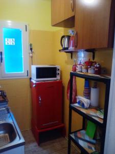 a kitchen with a red refrigerator and a microwave at AL MARE, AL SOLE, SI', ma nella CASA DEL MINATORE in Buggerru +28 photos