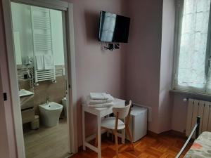 uma casa de banho com uma mesa e uma televisão na parede em La Bertina em Montefiascone