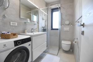 a bathroom with a washing machine and a sink at Apartment Maritimo in Zadar
