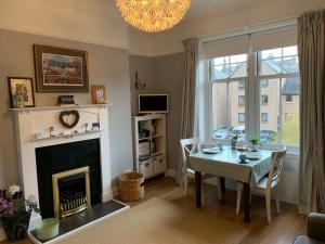 a living room with a table and a fireplace at Peebles Cottage Apartment with River View and Bike Store in Peebles