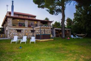 a group of white chairs in front of a house at VILLA GEM in Skiathos Town