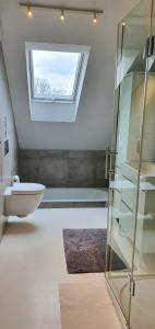 La salle de bains est pourvue de toilettes, d'un lavabo et d'une fenêtre. dans l'établissement loft 85 m2 Wilanow Krolewski self checkin, à Varsovie
