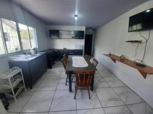a kitchen with a table and chairs and a sink at ACONCHEGO DE CANELA/RS in Canela