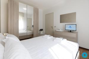 a bedroom with a large white bed and a television at Maji Como Lake Varenna in Varenna