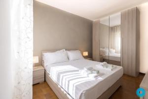 1 dormitorio con cama blanca y espejo en Maji Como Lake Varenna, en Varenna
