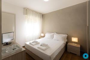 a bedroom with a white bed and a television at Maji Como Lake Varenna in Varenna
