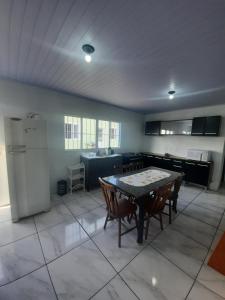 a kitchen with a table and chairs and a refrigerator at ACONCHEGO DE CANELA/RS in Canela
