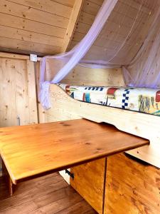ノイルピーンにあるMärchenhütte- Campen am Wald und Seeのベッド付きの部屋の木製テーブル