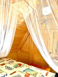 ノイルピーンにあるMärchenhütte- Campen am Wald und Seeのベッドルーム(蚊帳付きのベッド付)