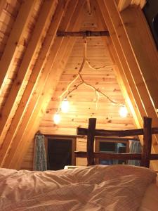 a bedroom in a log cabin with a ceiling with lights at Sultanmurat Bungalow in Çaykara