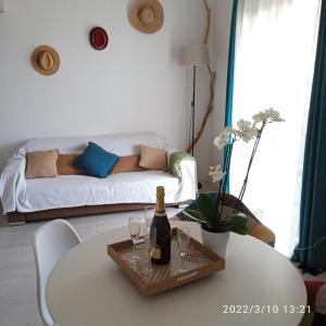 - un salon avec une table, des verres à vin et un canapé dans l'établissement Azzura, duplex lumineux accès direct à la plage, à Sainte-Maxime