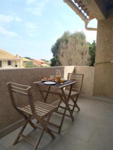 une table et deux chaises assises sur une terrasse dans l'établissement Azzura, duplex lumineux accès direct à la plage, à Sainte-Maxime