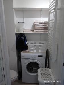 een wasmachine en droger in een kleine badkamer bij Azzura, duplex lumineux accès direct à la plage in Sainte-Maxime