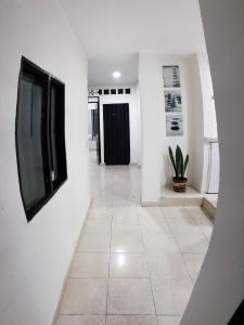 a hallway with white walls and a tv on a wall at Mapalay House in Ibagué