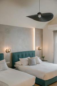 two beds in a bedroom with a ceiling fan at Socrates Apartments in Skala