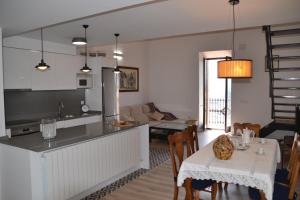 a kitchen and a living room with a table and chairs at Dúplex Dels Estudis in Morella