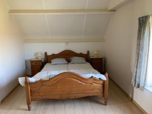 a bedroom with a wooden bed in a room at Vakantie-woning in Sint Kruis