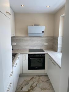 een keuken met witte kasten en een kookplaat oven bij Zum Franziskaner Dependance in Füssen