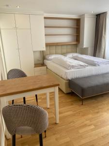 een kamer met twee bedden en een tafel en stoelen bij Zum Franziskaner Dependance in Füssen