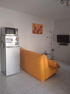 żółta kanapa w pokoju z lodówką w obiekcie Repos au vert en Ariège w mieście Le Peyrat