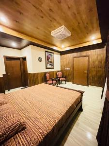 a bedroom with a bed and two chairs in it at Panorama Luxury House in Nathia Gali +30 photos