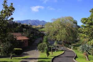 a winding road in a village with mountains in the background at Hotel Quinta Do Furao in Santana