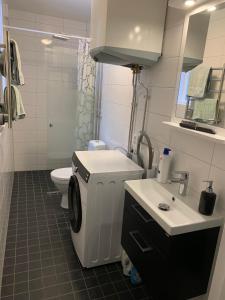 a white bathroom with a toilet and a sink at Linsell nyrenoverad lägenhet in Linsell