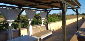 acovered patio with a couch and a table and a vineyard at Can Joan Barber, 1 in La Mola