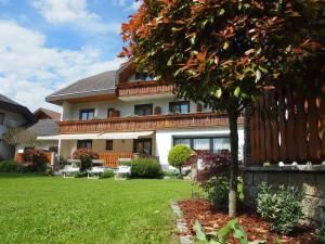 a large house with a tree in the yard at Pension Tulpe in Sankt Kanzian