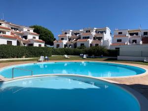 una grande piscina blu di fronte ad alcuni appartamenti di CASA DOCE Quinta Dos Arcos ad Alvor