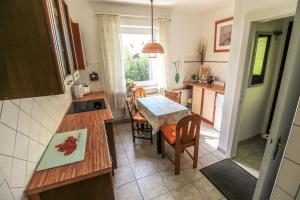 a kitchen with a table and a dining room at Ferienhaus auf einer Warft in Tetenbüll
