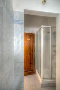 baño con ducha y puerta de madera en Sogni D'Oro Guest House, en Florencia