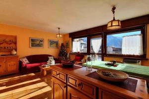 ein Wohnzimmer mit einem Sofa und einem Tisch in der Unterkunft Dolomiti Terrace Cavalese in Cavalese
